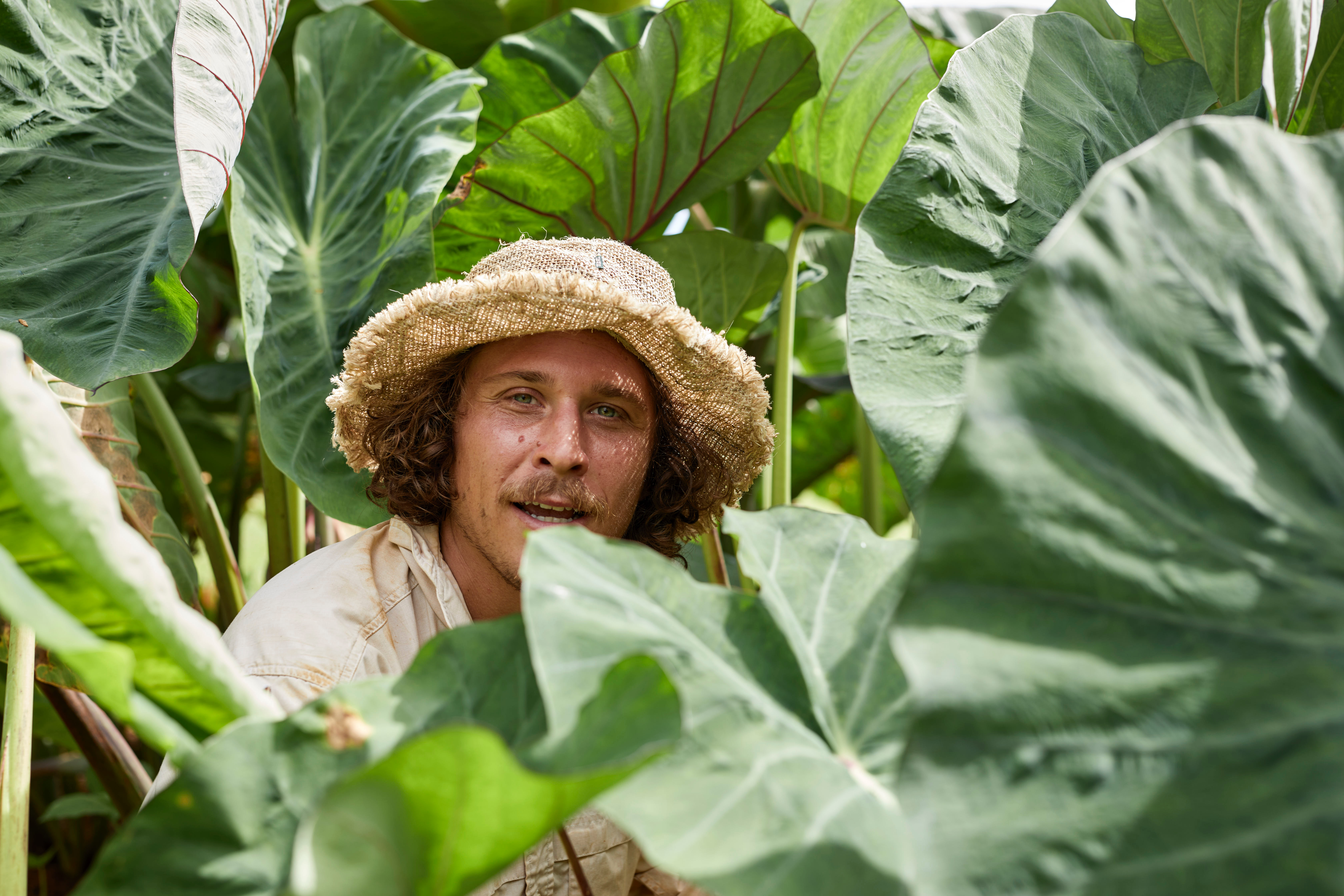 Kea Perkins surrounded by lush tropical plants, smiling warmly